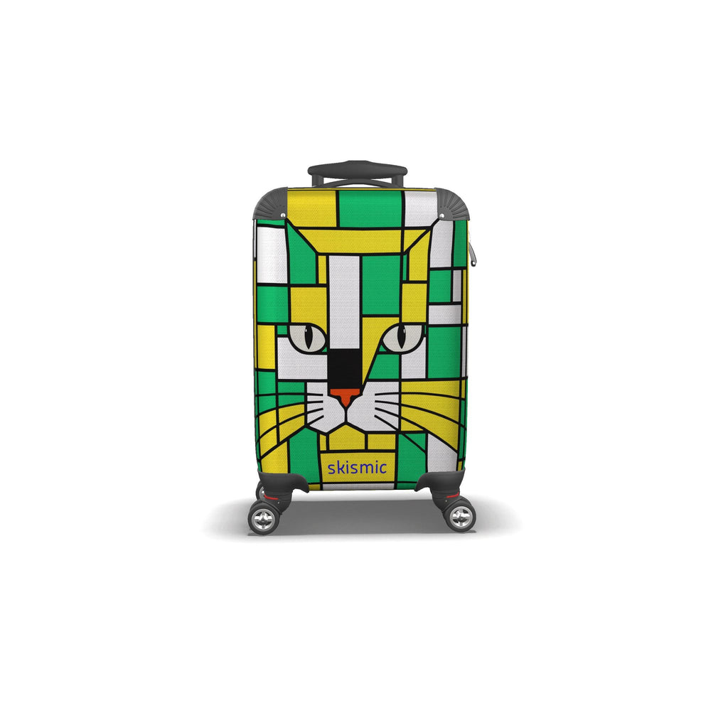 A hard-shell kids spinner suitcase featuring a colorful geometric cat face design in green, yellow, white, and gray, with the brand name 'skismic' printed near the bottom.